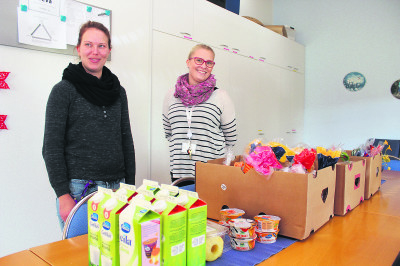 Ohjaaja Henna Suominen (vas.) ja valmentaja Milla Tuominen jakoivat maanantaina Sinivainiontiellä ruokatarvikkeita.
