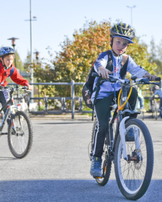 Samuel Kokkonen ja Joonas Lammi (edessä) kulkevat yhdessä kouluun. Kirkonkylällä asustavat pojat kertovat, että 1,5 kilometrin koulumatka sisältää tien ylityksiä, joilloin pyörät on talutettava.