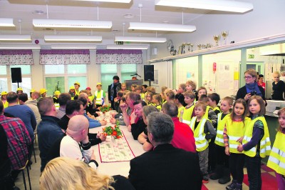 Siivikkalan koulun rehtori Jutta Marjamäki katseli tyytyväisenä (keskellä takana), kun koulun pienet oppilaat kävivät tervehtimässä harjannostajaisväkeä.