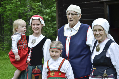 Nina Sahari (vas.), tyttäret Lina ja Nita sekä Reino Jumpponen ja Eine Sahari tuulettivat kansallispukujaan Vänrikki Stoolin tuvalla. Perheen puvut olivat Eine Saharin käsialaa.