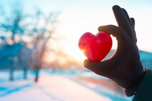 hand with heart on winter background