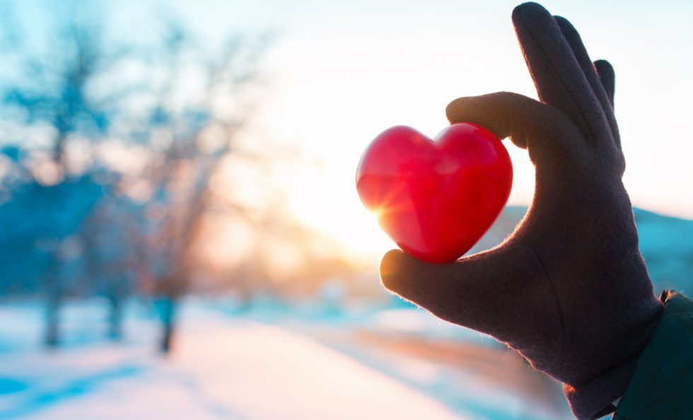 hand with heart on winter background